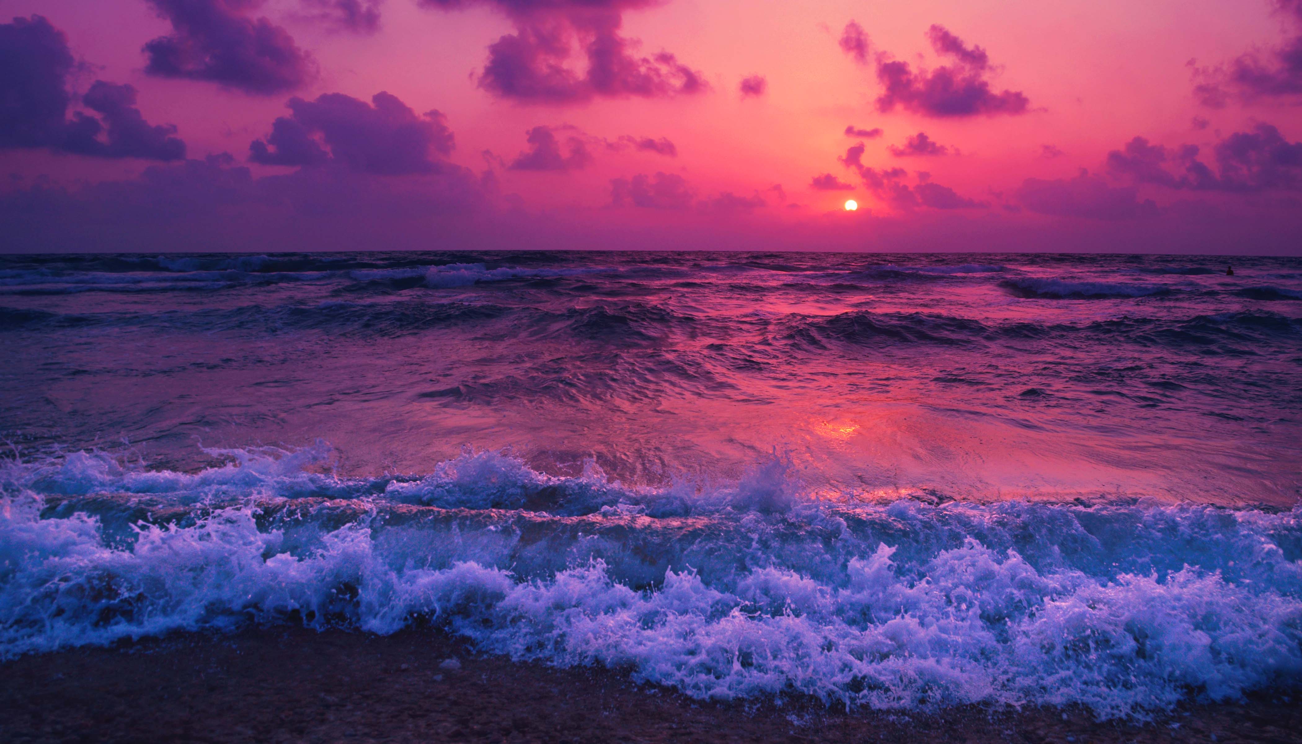 Waves Washing Ashore With A Pink Sunset